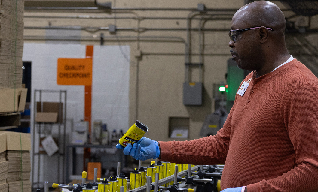 man inspects goof off packaging on the production line.